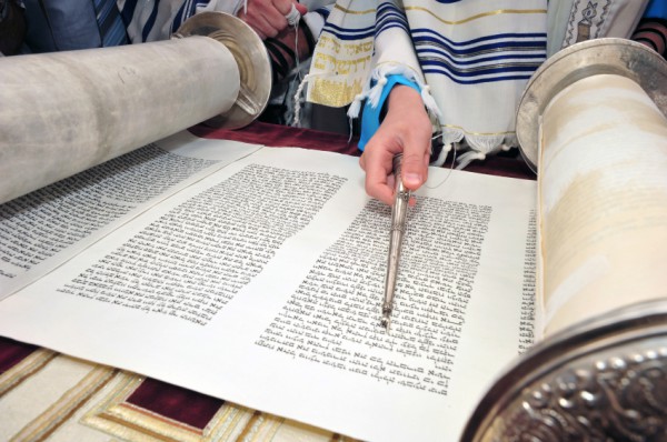 Reading the Torah scroll with a pointer called a yad (literally, hand).