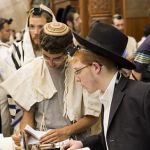 Young-Jewish-men-read-Torah-scrolls-Western-Wall-Jerusalem