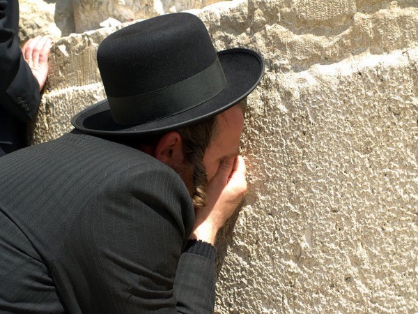 An Orthodox Jewish man prays earnestly at the Western Wall