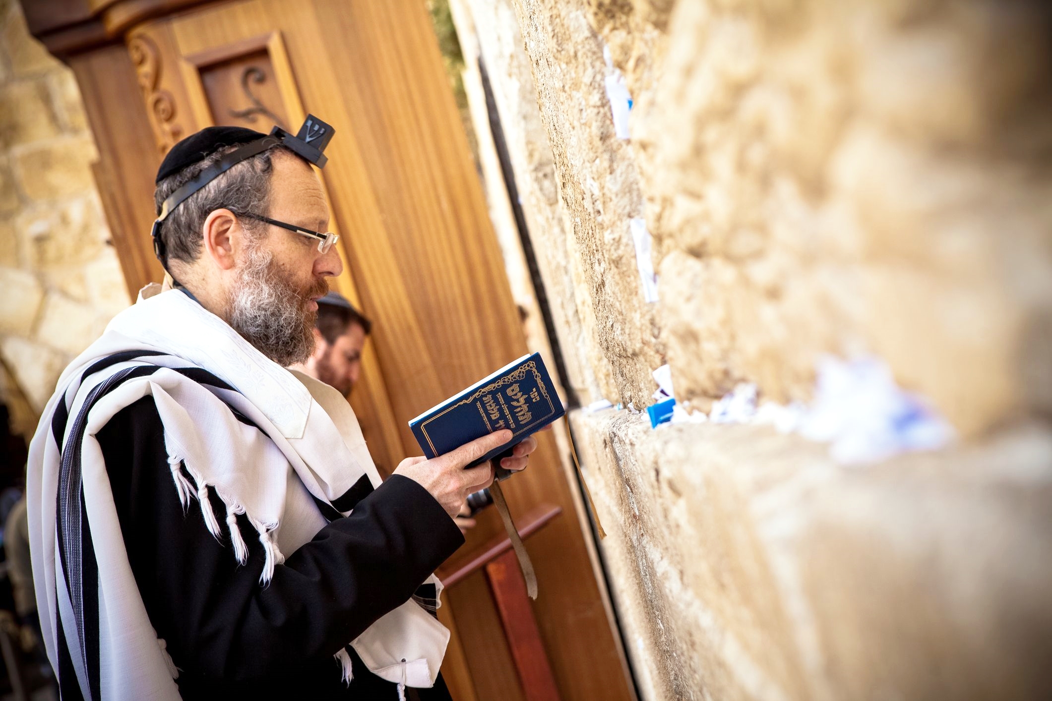 A Jewish man recites the Psalms (Tehillim) during morning prayer at the Western (Wailing) Wall.