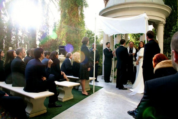 A Jewish bride and groom exchange vows under the chuppah.