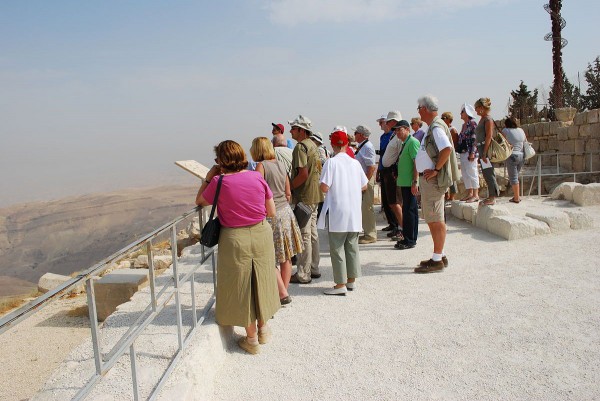 Pilgrims and tourists consider the view from Mount Nebo.