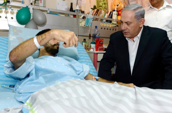 Prime Minister Benjamin Netanyahu visits an Israeli soldier who was wounded during Operation Protective Edge.