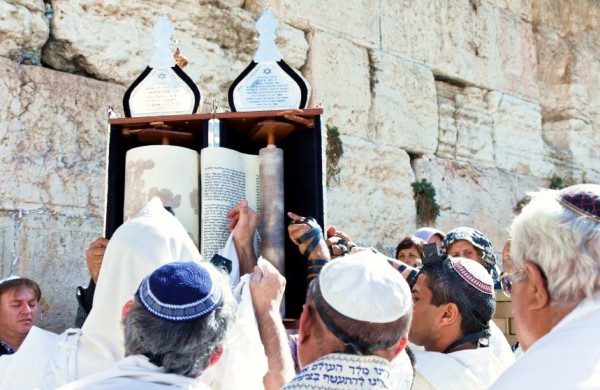 Jewish men pay reverence to the Torah at the Western (Wailing) Wall.