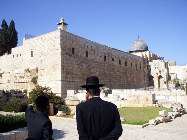 An Orthodox Jewish man points to the remains of Robinson's Arch, a monumental staircase built by Herod that was supported by an unusually wide stone arch. It stood at the southwestern corner of the Temple Mount.