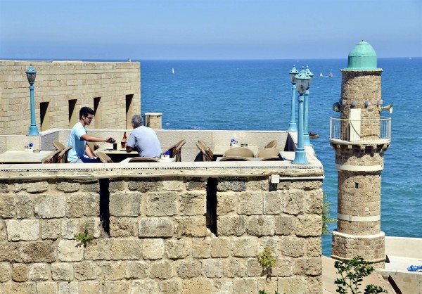 People have a bite to eat on a restaurant patio in Jaffa, Israel.