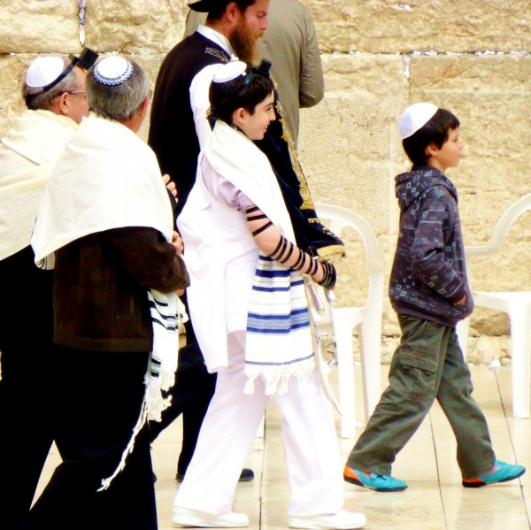 A 13-year-old Jewish boy carries the Torah scroll publicly for the first time at the Western (Wailing) Wall in Jerusalem.