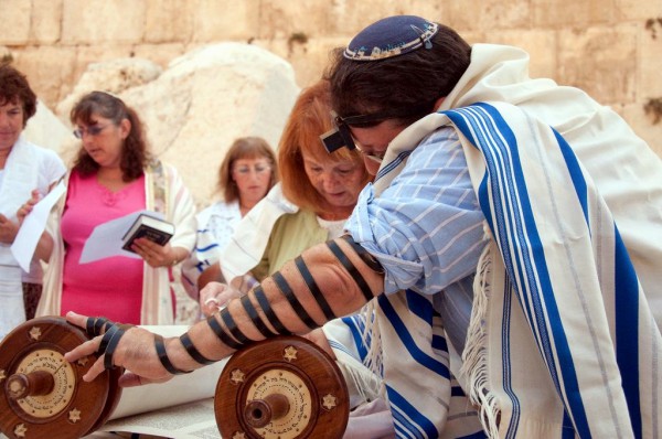 A woman reads from the Torah scroll in Jerusalem near the Western (Wailing) Wall. (Photo by Josh Evnin)