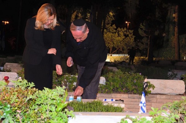 Prime Minister Benjamin Netanyahu and his wife Sara pay tribute to Israel's fallen soldiers at the Mount Herzl cemetery in Jerusalem, lighting a candle for Yonatan Netanyahu.