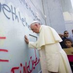 Pope Frances prays at the separation barrier