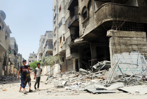 Three Palestinian youth inspect the remains of a house after it was hit in Israeli air strike in the Sheikh Radwan district against Muhammed Deif, the head of Hamas' military wing.  (UN photo by Shareef Sarhan) 