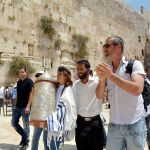 A 13-year-old Jewish teen carries the Torah scroll at the Western (Wailing) Wall in Jerusalem.