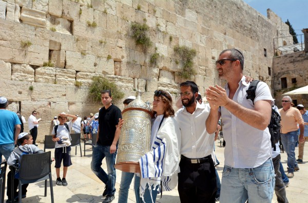 A 13-year-old Jewish teen carries the Torah scroll at the Western (Wailing) Wall in Jerusalem.