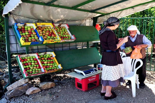 A Jewish woman buys fruit from a Druze Muslim in the Golan Heights.