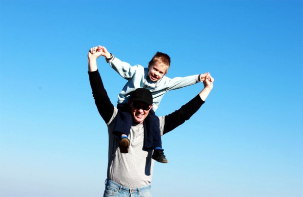 An Israeli father carries his son on his shoulders as they hike in the wilderness.