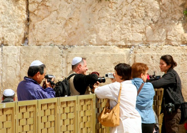 Tourists try to get a good photograph over the mechitza (barrier between the men's and women's side) at the Western Wall. (Photo by Avital Pinnick)