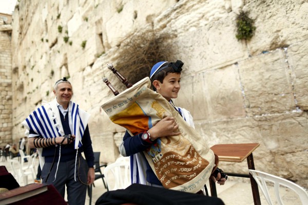 A 13-year-old Jewish boy carries the Torah scroll at the Western (Wailing) Wall. (Israel Ministry of Tourism photo by Jonathan Sindel)