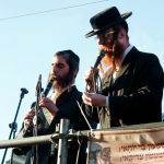 Two ultra-Orthodox Jewish men in Meron, Israel play music during a Jewish holy day.