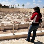 A woman examines a model of what the Temple Mount (upper left hand corner) and Jerusalem would have been like during the Second Temple period.