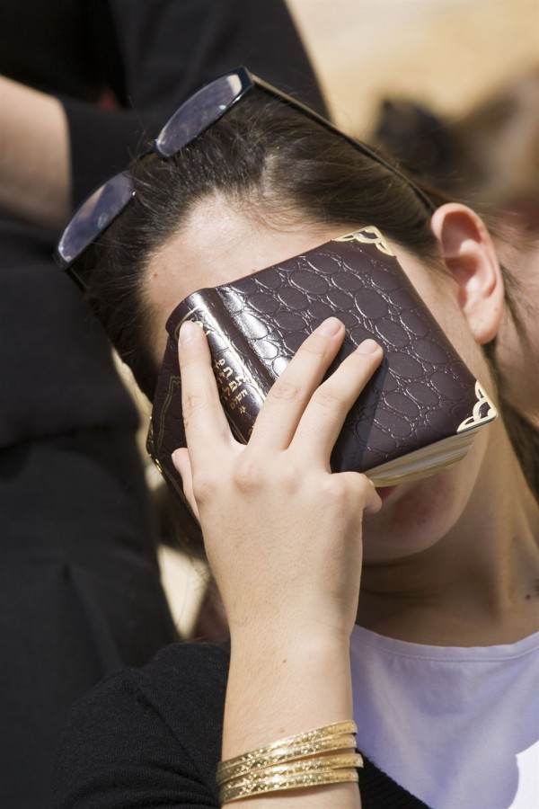 A Jewish woman buries her face in her siddur (prayer book) as she prays at the Western (Wailing) Wall in Jerusalem.