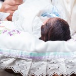 a baby boy lays on his brit milah (circumcision) pillow